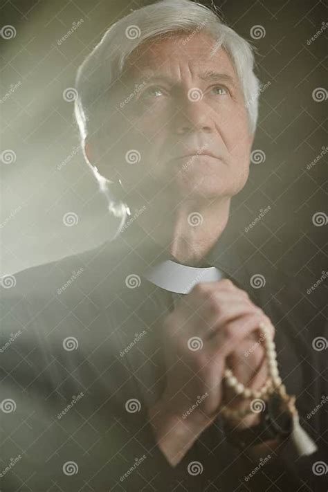 Ritratto di un sacerdote anziano in abiti clericali, con sfondo sfocato