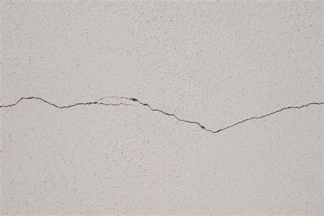 Foto ravvicinata di crepe nei muri di una struttura dell'eremo dopo il terremoto, con un focus sui danni