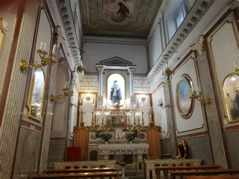 Interno della casa di Santa Maria Francesca con pareti ricoperte di ex-voto, nastri e foto