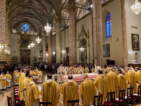 Interno di una chiesa con fedeli e clero durante una messa funebre
