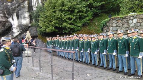 Foto di gruppo di militari di diverse nazioni in uniforme a Lourdes davanti alla Grotta di Massabielle