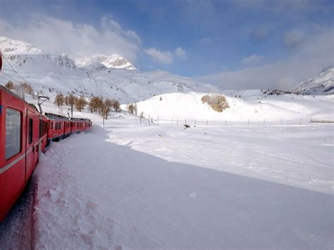 Trenino Rosso del Bernina innevato che attraversa un paesaggio alpino