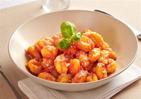 Patate al sugo con foglie di basilico fresco