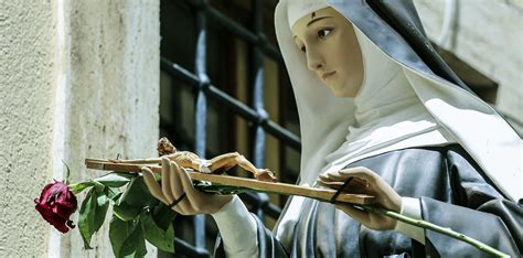 Dettaglio della statua di Santa Rita da Cascia, mostrando la veste agostiniana, la corona del Rosario e la piaga sulla fronte.