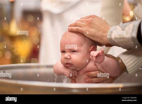 padrino e madrina con bambino durante un battesimo ortodosso