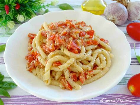 Piatto di pasta fresca artigianale siciliana, come busiati o maccarruna, con ingredienti tipici.
