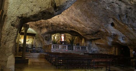 Foto panoramica della Grotta di San Michele Arcangelo con la sua architettura esterna e il paesaggio circostante