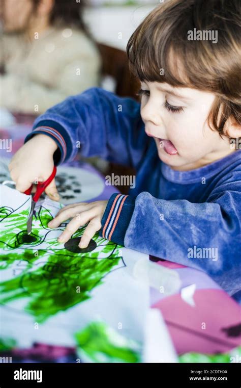 Bambini che ritagliano e colorano biglietti a forma di cuore