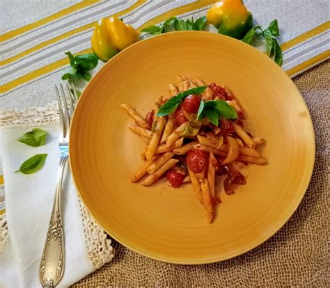 Piatto di pennette con pomodorini e basilico fresco