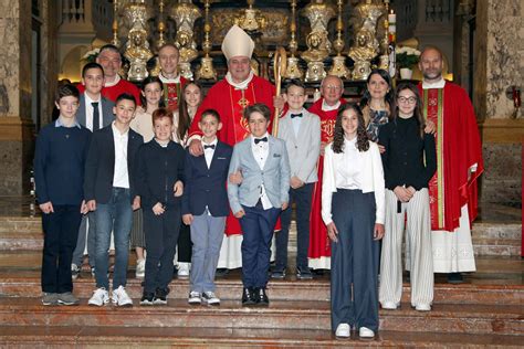 Foto di gruppo di cresimandi adulti con il sacerdote durante la cerimonia della Cresima