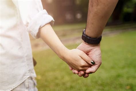 Coppia anziana che si tiene per mano e si sorride, simbolo di amore e cura familiare