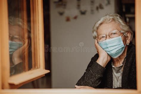 Immagine simbolica di solitudine, come una persona anziana che guarda fuori da una finestra
