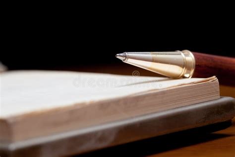 Primo piano di una penna stilografica elegante su un taccuino, simbolo di un regalo classico e duraturo