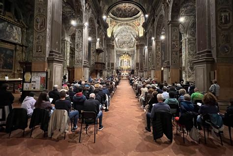 Foto di una veglia di preghiera in una chiesa gremita di fedeli con candele