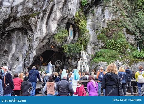 Pellegrini in preghiera davanti alla Grotta di Massabielle con candele accese