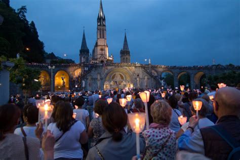 Pellegrini con candele durante la processione serale a Lourdes