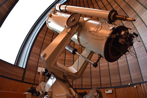Interno di un osservatorio astronomico con un telescopio che punta verso il cielo notturno stellato