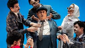 Gianni Fantoni sul palco, interpretando Fantozzi, con enfasi drammatica.