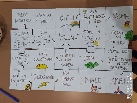 Bambini che assemblano un puzzle con frasi del Padre Nostro e disegni
