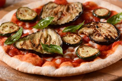 Piatto di pizza rossa con melanzane e parmigiano