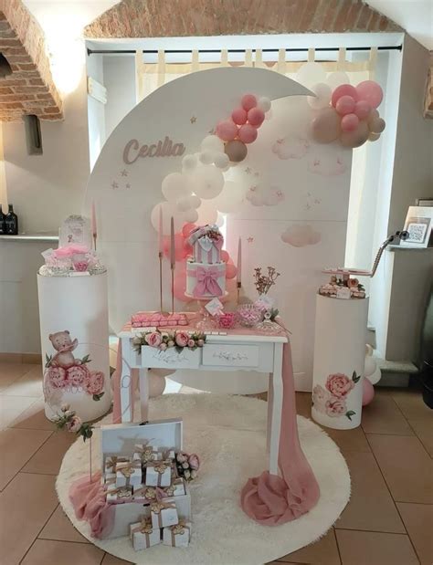 Centrotavola fai-da-te per battesimo bimba con palloncini rosa e oro e elementi floreali.