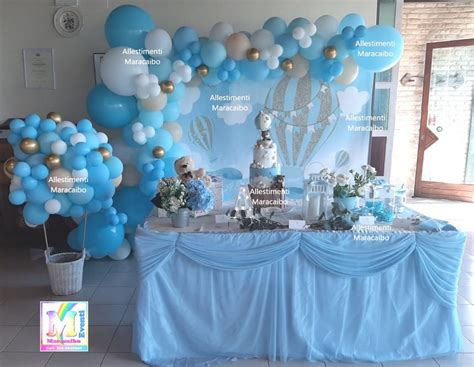 Esempio di allestimento a tema angeli con palloncini, festoni e centrotavola coordinati.