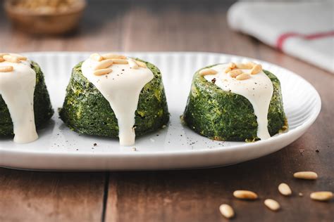 Foto di un flan di spinaci ben impiattato accanto a una fetta di torta salata agli asparagi