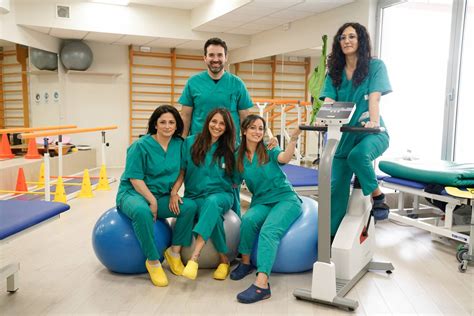 Foto di palestra attrezzata per la riabilitazione con fisioterapisti e pazienti