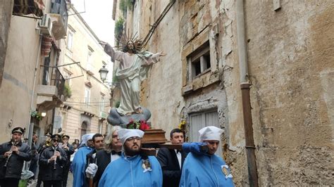 Pellegrini che toccano e raccolgono il liquido dal ginocchio del Cristo Risorto