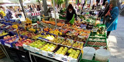Illustrazione di una persona che fa la spesa al mercato con verdure fresche e prodotti locali