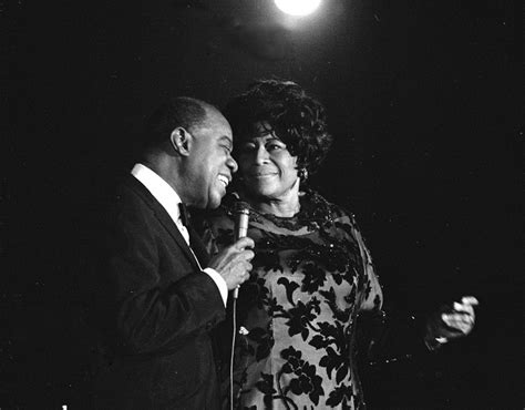 Ella Fitzgerald sul palco, microfono in mano, durante un'esibizione energica