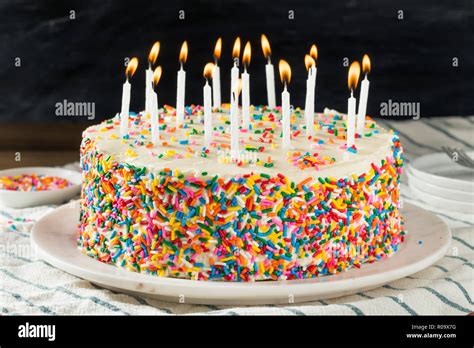 Torta di compleanno con candele a forma di 60 e persone che festeggiano