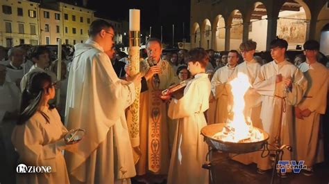 Sacerdote che canta il Gloria durante la Veglia Pasquale, con la chiesa illuminata a festa
