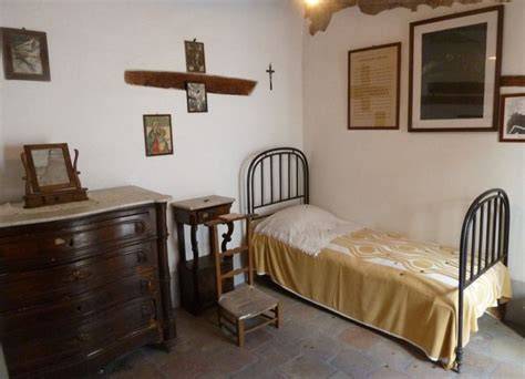 interno della cella di Padre Pio con letto e poltrona