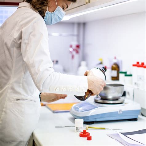 Immagine di un farmacista che prepara una soluzione nel laboratorio galenico