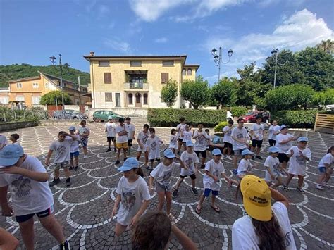 Foto di bambini e animatori che si divertono in attività all'aperto durante il Grest estivo della scuola Pio XII