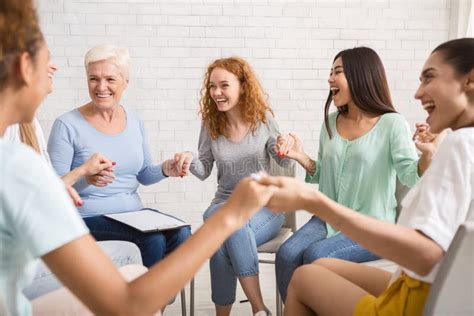 Un gruppo di donne sedute in cerchio, che tengono per mano una futura mamma, simbolo di un Blessing Way.