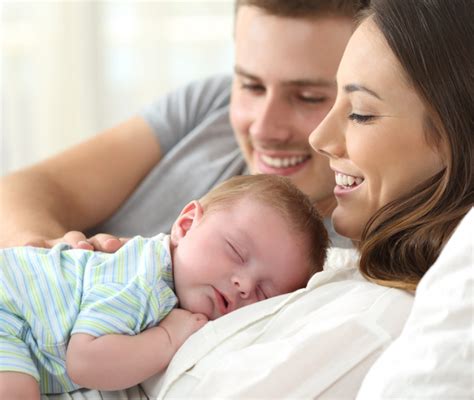 Foto di un bambino appena battezzato con i genitori e i padrini
