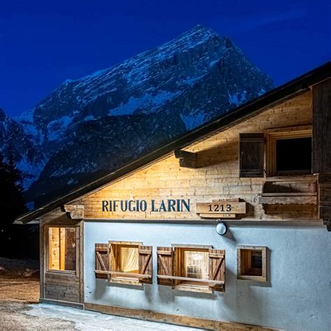 Interno del rifugio con il tipico larin acceso e piatti della tradizione montana cadorina