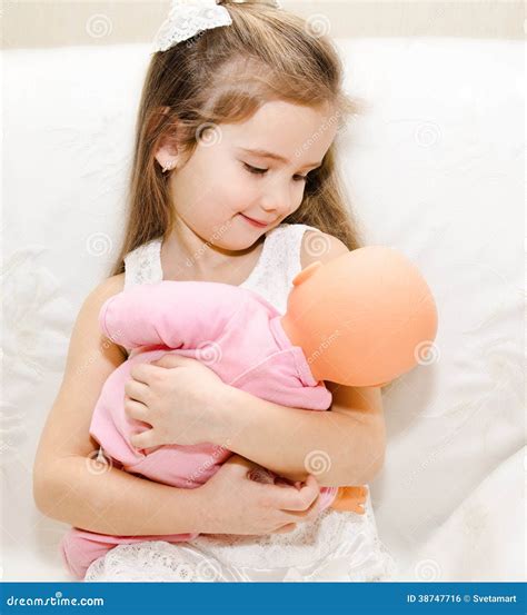 Bambina che gioca con una bambola di stoffa in un ambiente sereno