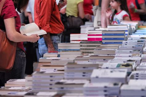 Libreria affollata con persone che leggono e sfogliano libri, con etichette di recensioni che fluttuano sopra alcune copertine