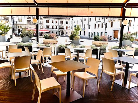 Interno di un ristorante italiano accogliente con tavoli in legno e un'atmosfera calda