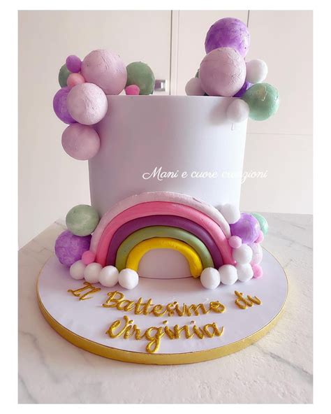 Immagine di torta battesimo dai colori pastello con fiocchi