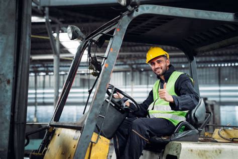 Foto di un operaio che lavora con un carrello elevatore in un magazzino