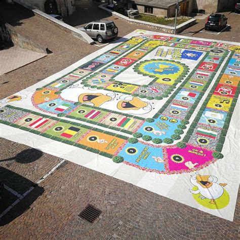 Tavolo con diverse postazioni di gioco per la catechesi, come un gioco dell'oca gigante, carte e cruciverba