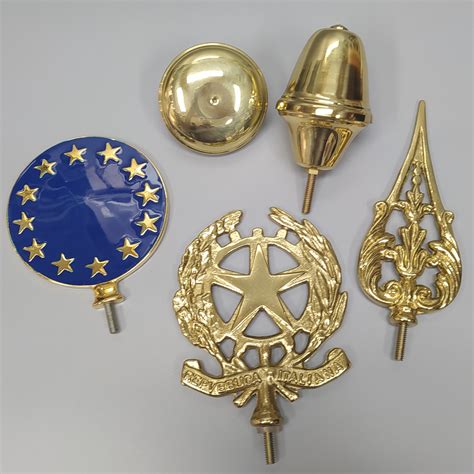 Foto che mostra diverse tipologie di puntali per bandiere (lancia, pomolo, emblema)