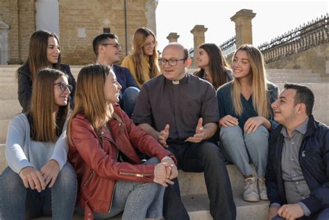 Un sacerdote che parla con giovani, illustrando il tema della vocazione