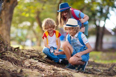 Bambini che esplorano la natura in un parco, imparando a riconoscere piante