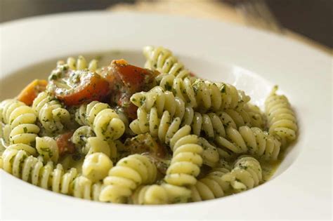Piatto di fusilli al pesto con basilico fresco e pomodorini