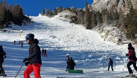 Immagine di sciatori su una pista con vista sul Passo Gardena